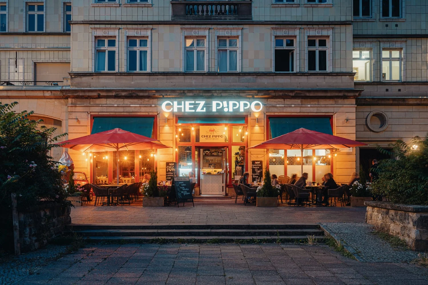 Abendliche Außenansicht von Chez Pippo mit beleuchteter Terrasse