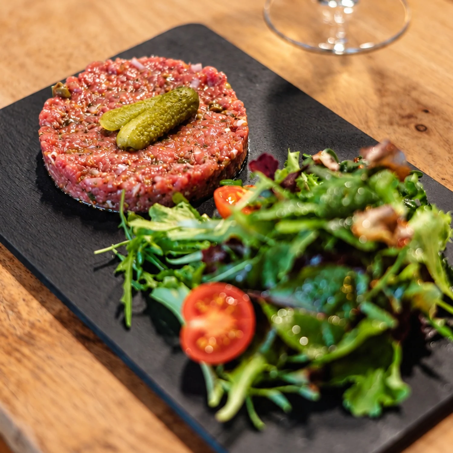 Tatar de Bœuf mit Salat auf einer schwarzen Steinplatte